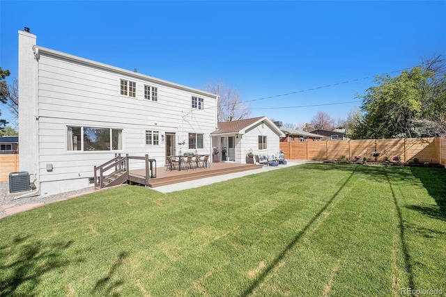 back of property featuring a yard, fence private yard, a wooden deck, and a chimney