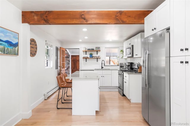 3521 W 40th Ave, Denver, CO 80211 - kitchen with appliances with stainless steel finishes, a sink, a baseboard radiator, tasteful backsplash, and light wood finished floors