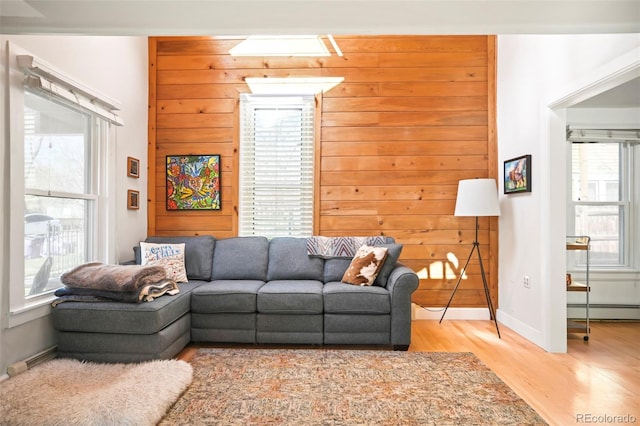 3521 W 40th Ave, Denver, CO 80211 - living room with a baseboard radiator, light wood-style floors, wooden walls, and baseboards