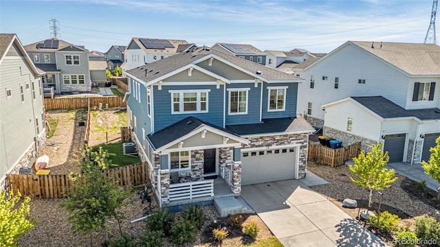 118 N Newcastle Way, Aurora, CO 80018 - craftsman house with an attached garage, concrete driveway, a residential view, a porch, and stone siding