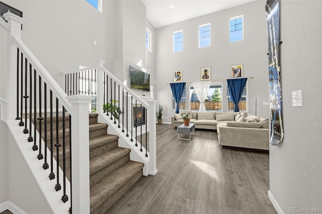 118 N Newcastle Way, Aurora, CO 80018 - living room with a high ceiling, wood finished floors, stairway, and baseboards