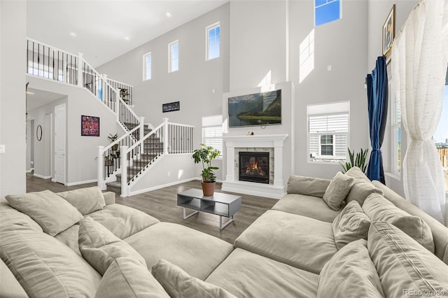 118 N Newcastle Way, Aurora, CO 80018 - living room with a high ceiling, wood finished floors, recessed lighting, a glass covered fireplace, and stairs