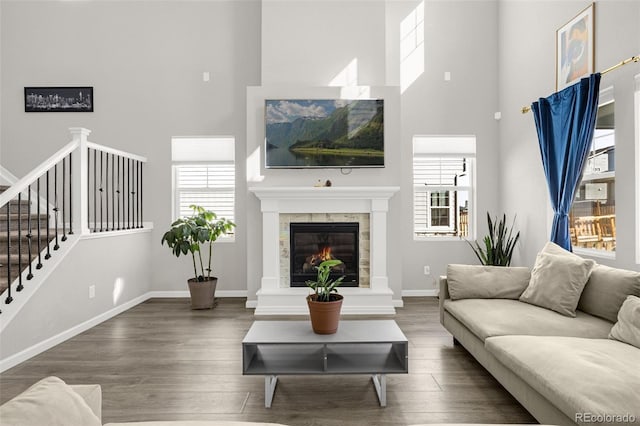 118 N Newcastle Way, Aurora, CO 80018 - living room featuring a towering ceiling, plenty of natural light, wood finished floors, baseboards, and stairway