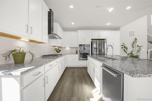 118 N Newcastle Way, Aurora, CO 80018 - kitchen with wall chimney range hood, appliances with stainless steel finishes, a sink, dark wood-type flooring, and white cabinets