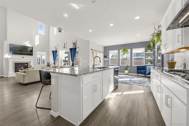 118 N Newcastle Way, Aurora, CO 80018 - kitchen featuring open floor plan, wall chimney exhaust hood, plenty of natural light, a sink, and recessed lighting
