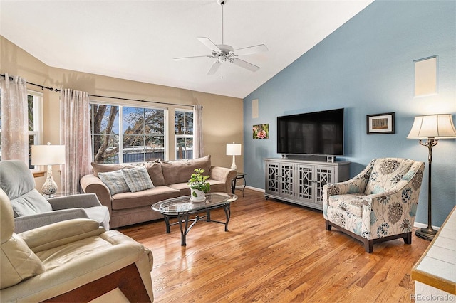 living room featuring vaulted ceiling, a wealth of natural light, ceiling fan, and light hardwood / wood-style floors