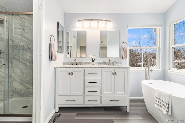 bathroom with hardwood / wood-style flooring, vanity, and separate shower and tub