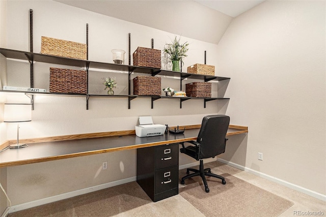 office with lofted ceiling, built in desk, and carpet floors