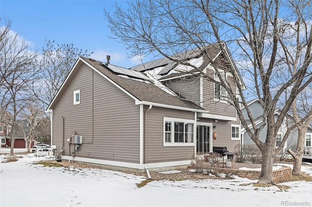 snow covered property with solar panels