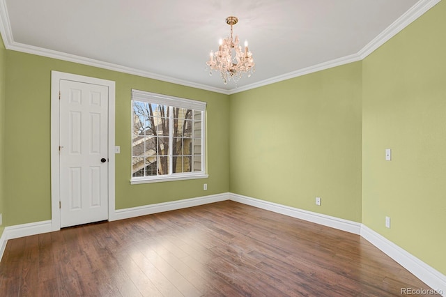 unfurnished room featuring an inviting chandelier, crown molding, baseboards, and wood finished floors