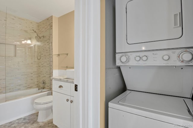 clothes washing area featuring stacked washer and clothes dryer and laundry area