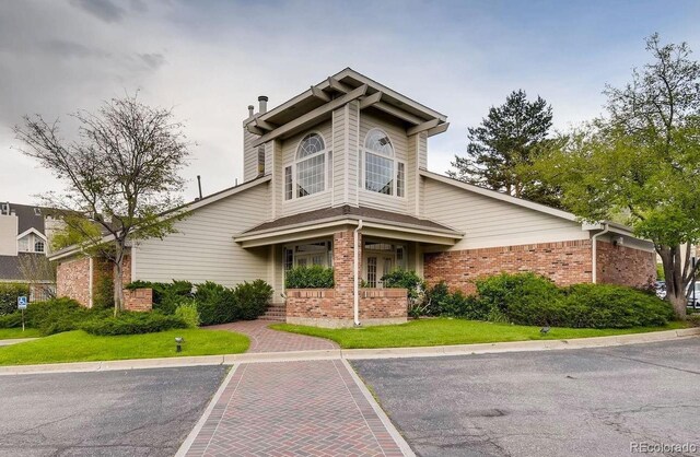 view of front of home with a front yard and brick siding