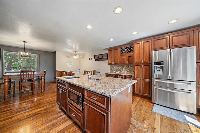 10714 Birch Ct, Thornton, CO 80233 - kitchen featuring stainless steel appliances, light wood-style floors, backsplash, light stone countertops, and recessed lighting