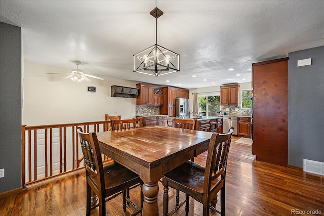 10714 Birch Ct, Thornton, CO 80233 - dining area with dark wood finished floors, a ceiling fan, recessed lighting, and a chandelier