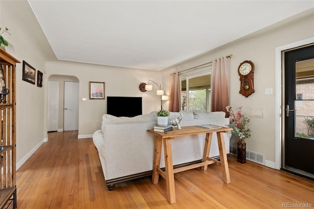 1432 Xanthia St, Denver, CO 80220 - living area with arched walkways, light wood finished floors, and baseboards