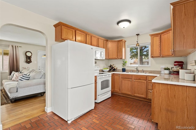 1432 Xanthia St, Denver, CO 80220 - kitchen with white appliances, a sink, brick patterned flooring, light countertops, and hanging light fixtures