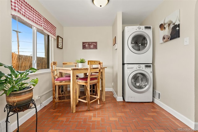 1432 Xanthia St, Denver, CO 80220 - laundry room with stacked washing machine and dryer, brick floors, and baseboards