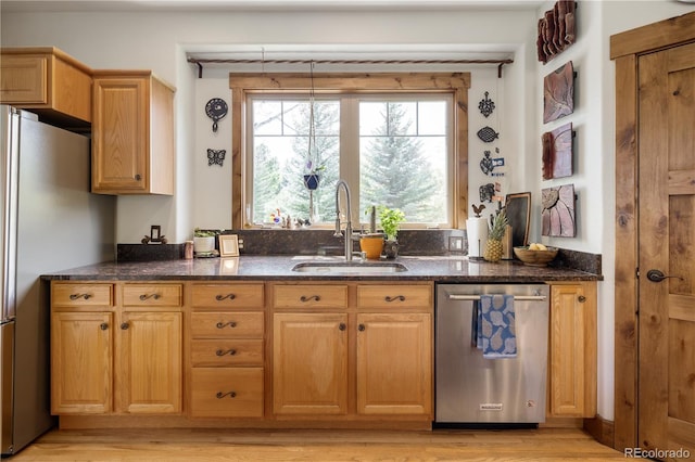 1654 Muirfield Ln, Evergreen, CO 80439 - kitchen with stainless steel appliances, a sink, light wood-style flooring, and dark stone countertops