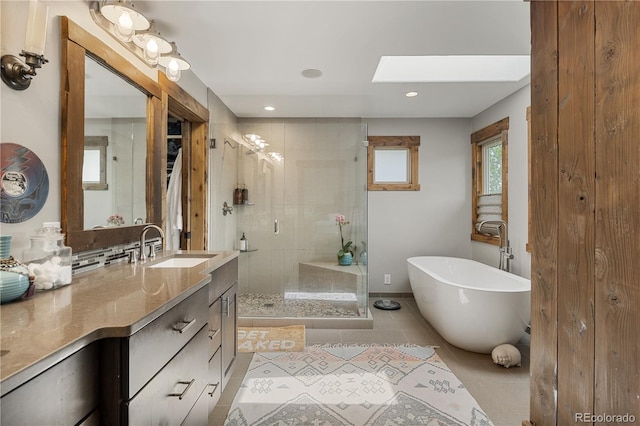 1654 Muirfield Ln, Evergreen, CO 80439 - full bath with vanity, a stall shower, a freestanding tub, tile patterned floors, and a skylight