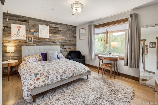 1654 Muirfield Ln, Evergreen, CO 80439 - bedroom featuring wooden walls, an accent wall, wood finished floors, and baseboards