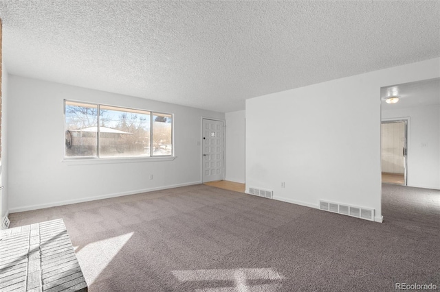 spare room featuring a textured ceiling and carpet flooring