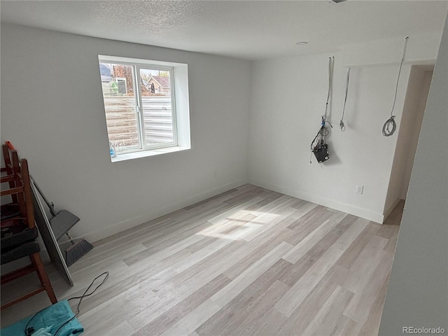 empty room featuring baseboards and light wood-style floors