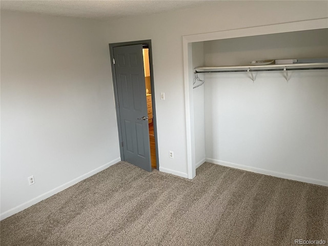 unfurnished bedroom with carpet, baseboards, and a closet