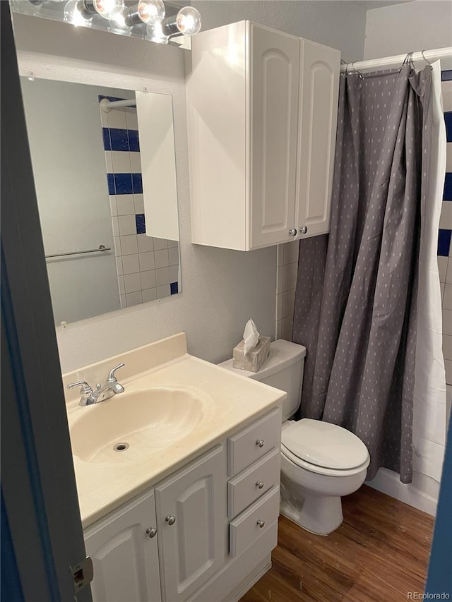 full bathroom with vanity, a shower with shower curtain, wood finished floors, and toilet
