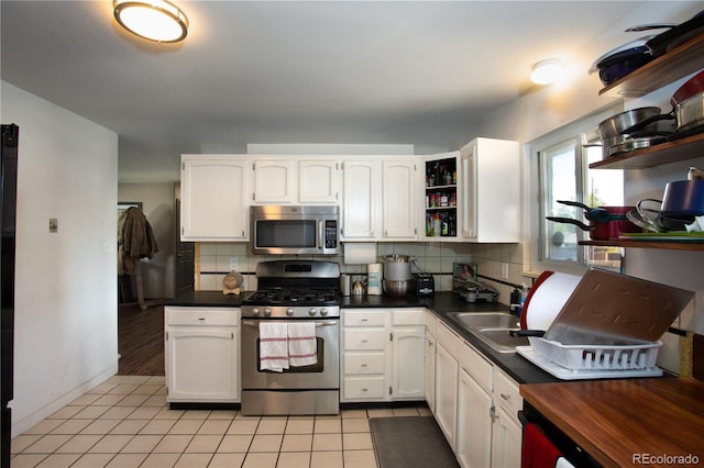 201 Monmouth Ave, Firestone, CO 80520 - kitchen with appliances with stainless steel finishes, open shelves, dark countertops, white cabinets, and tasteful backsplash