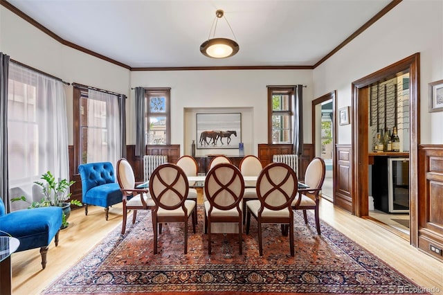 1437 Columbine St, Denver, CO 80206 - dining room featuring wood finished floors, wainscoting, ornamental molding, beverage cooler, and radiator heating unit