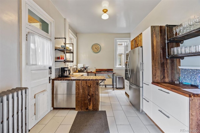 1437 Columbine St, Denver, CO 80206 - kitchen featuring radiator, freestanding refrigerator, wooden counters, and open shelves