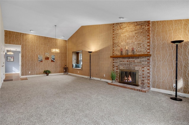 unfurnished living room featuring carpet floors, lofted ceiling, a fireplace, and wallpapered walls