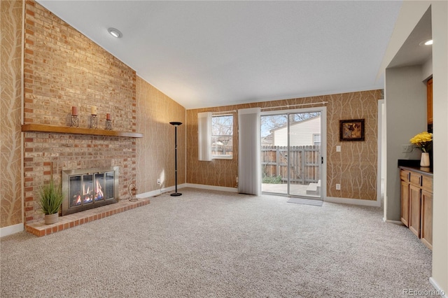 unfurnished living room with recessed lighting, light carpet, baseboards, vaulted ceiling, and a brick fireplace