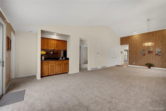 unfurnished living room featuring visible vents, vaulted ceiling, light carpet, and baseboards