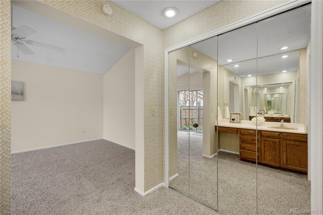 bathroom featuring double vanity, baseboards, ceiling fan, a sink, and recessed lighting