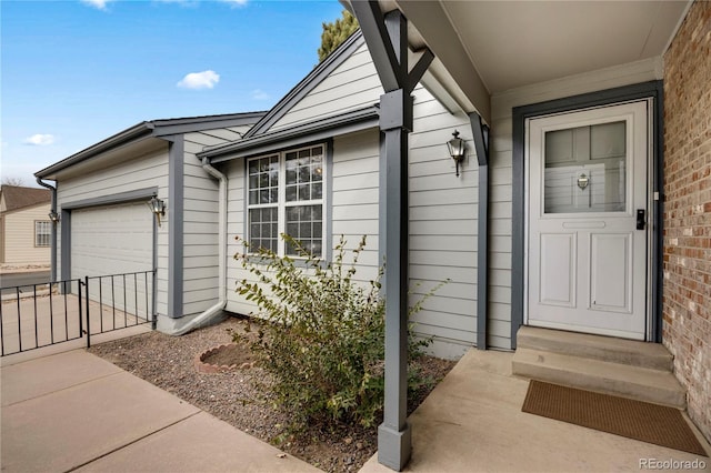 property entrance with brick siding, driveway, and an attached garage