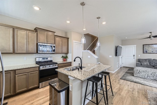21751 E 7th, Aurora, CO 80018 - kitchen with stainless steel appliances, tasteful backsplash, open floor plan, light wood-type flooring, and recessed lighting