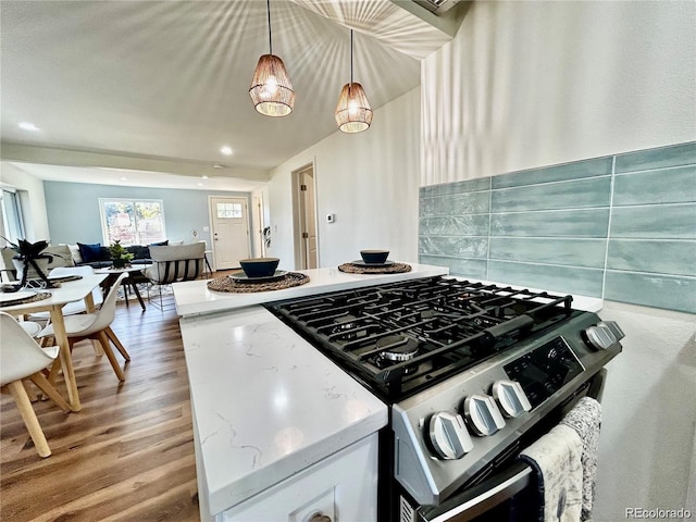 601 W Layton Ave, Englewood, CO 80110 - kitchen with stainless steel gas range, wood finished floors, decorative backsplash, open floor plan, and pendant lighting