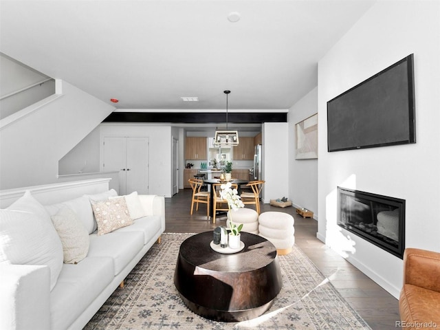 living room featuring lofted ceiling, hardwood / wood-style floors, and a chandelier