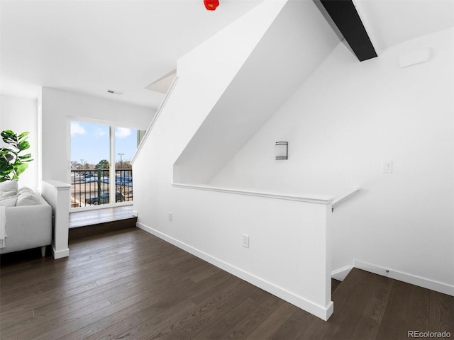 additional living space featuring beam ceiling and dark hardwood / wood-style floors