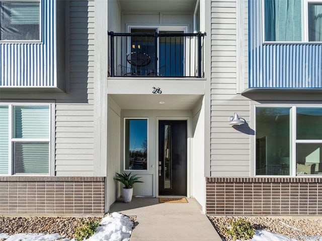 view of exterior entry with a balcony