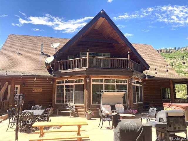 rear view of property with a balcony, a patio area, and an outdoor hangout area