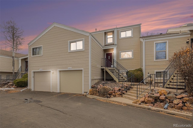 view of front of property with a garage, driveway, and stairway