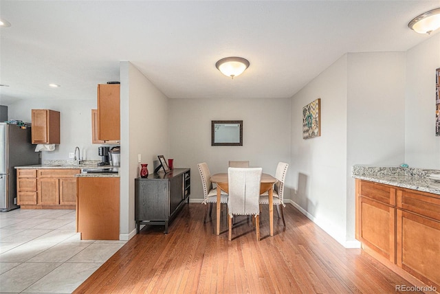 dining space with baseboards, recessed lighting, and light wood-style floors