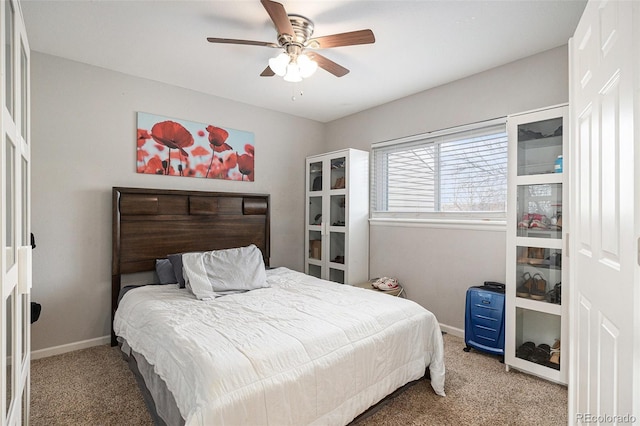 bedroom with a ceiling fan, baseboards, and carpet flooring