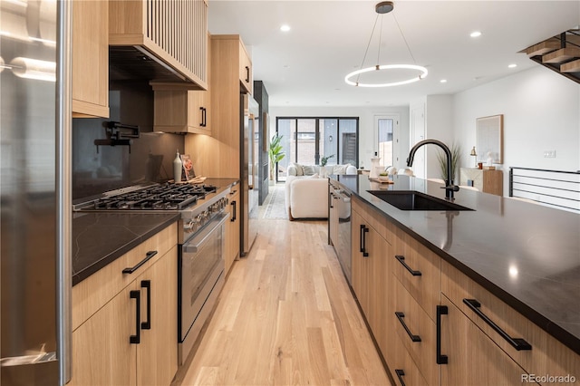 4301 Osceola St, Denver, CO 80212 - kitchen featuring stainless steel appliances, light brown cabinets, light wood finished floors, open floor plan, and premium range hood