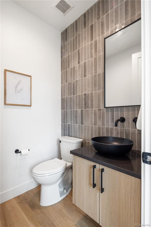4301 Osceola St, Denver, CO 80212 - bathroom featuring vanity, wood finished floors, decorative backsplash, and tile walls