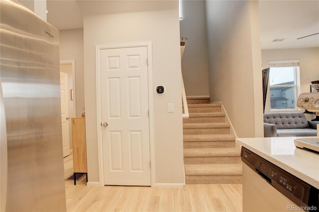 stairway with visible vents, baseboards, and wood finished floors