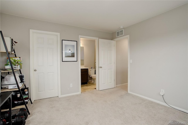 unfurnished bedroom with light colored carpet, visible vents, baseboards, and ensuite bathroom