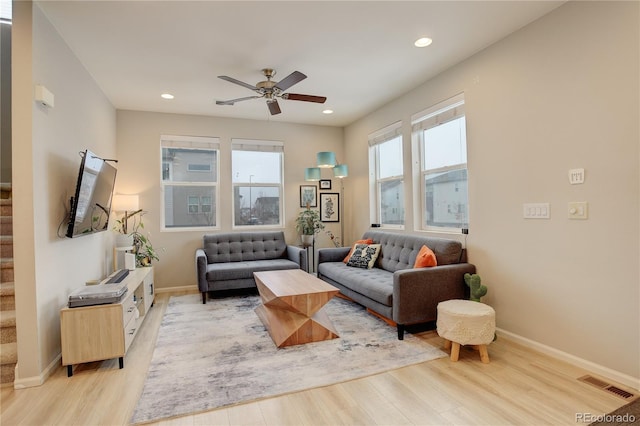 living room with stairs, light wood-style flooring, recessed lighting, and visible vents